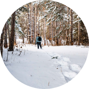 Person backpacking in winter woods.