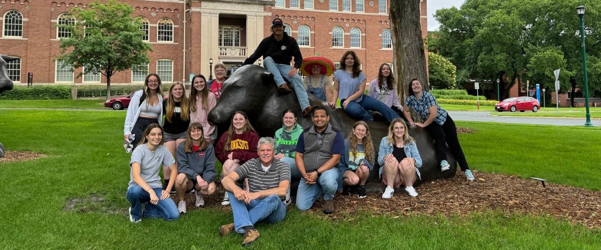 Midwest Poultry Consortium summer program students pose by CFANS bull