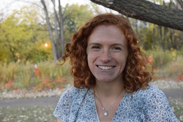 Jess Jurcek smiles in a blue and white shirt.