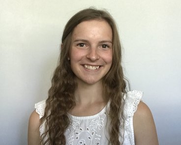 Lauren Kreager smiles in front of a white background.