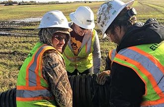 Helping the crew from Ellingson join two pieces of drainage pipe together during installation in October 2019. Photo by Mike Enright of Ellingson Drainage.