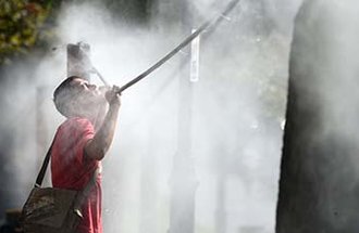 A man cools off with water spray frames in Ukraine during a heat wave.