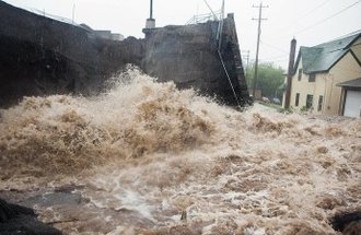 Flood water rushing through a town.