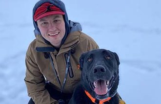 Sawyer Scherer with his black lab.