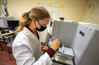 Plant Protein Innovation Center student working on a machine.