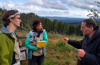 Tyler Baumann and Sara DeLaurentis talk with someone while collecting samples.