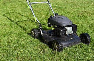 Push lawnmower on a green lawn.