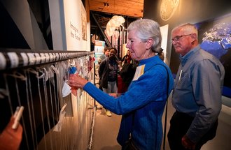 A guest adding to an interactive exhibit about climate change